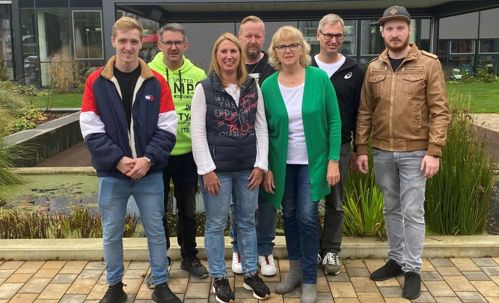 Das 7-köpfige Team vor einem modernen Gebäude