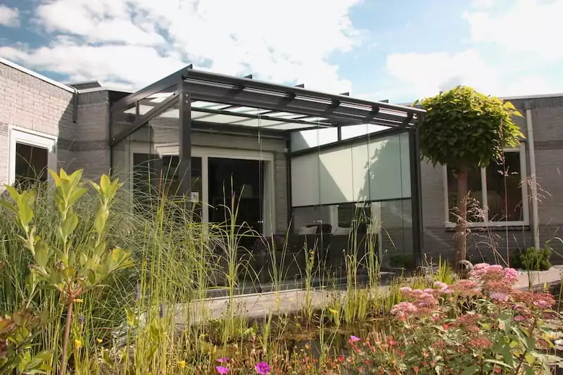 Eine Terrasse mit Glasüberdachung im Grünen