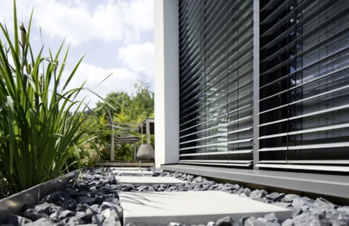 Moderne Jalousien an einem Haus mit Garten